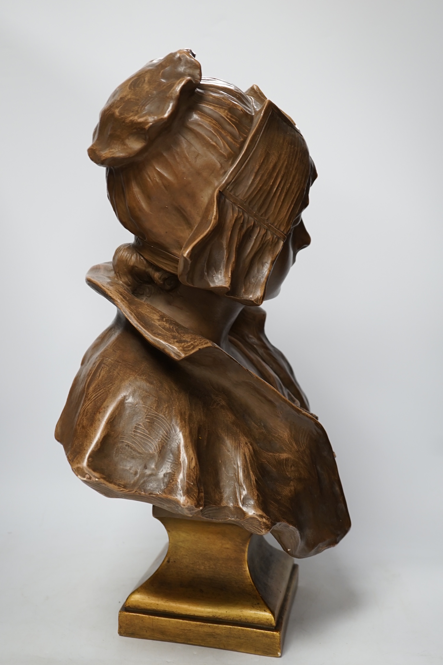 A bronzed terracotta bust of an early 20th century Dutch girl, 55cm high